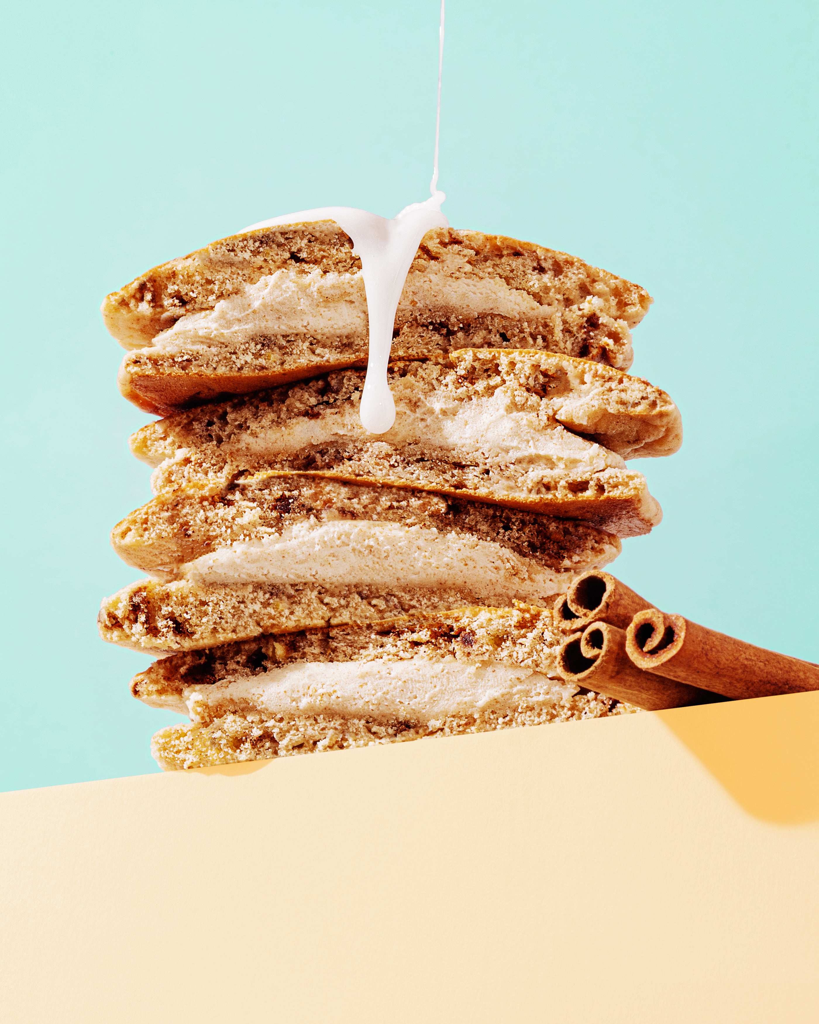 Cinnamon Bun Pancake Sandwich Stacked with milk falling on them