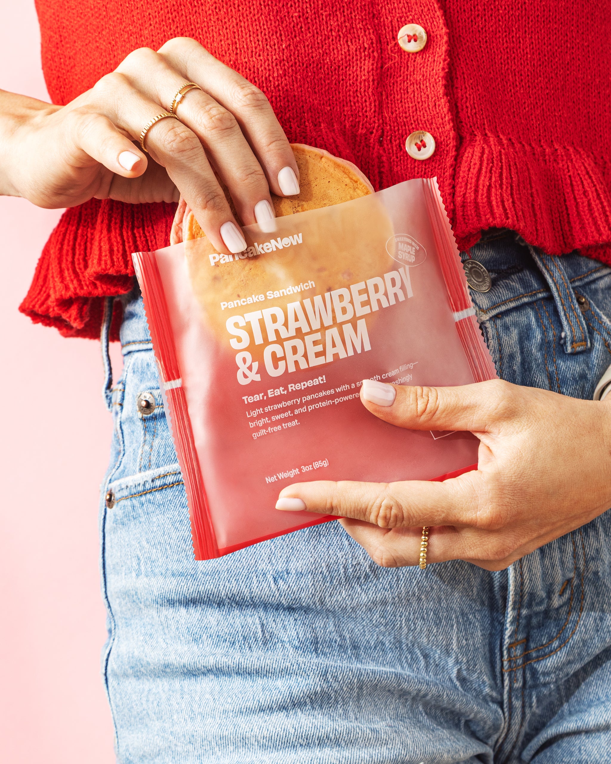 Person holding a package of Pancake Sandwich Strawberry & Cream snack.